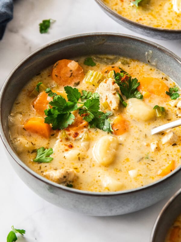 a grey bowl of Instant Pot chicken gnocchi soup with a spoon