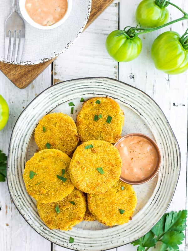 a plate of fried green tomatoes on a white board with small green tomatoes