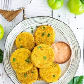 a plate of fried green tomatoes on a white board with small green tomatoes