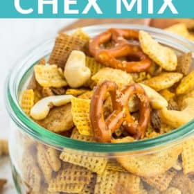 a glass bowl with Chex Mix on a white board