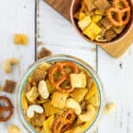 a glass bowl with Chex Mix on a white board