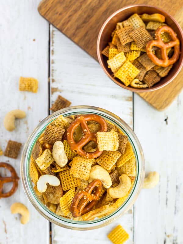 a glass bowl with Chex Mix on a white board