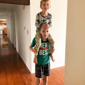 a boy giving another boy a ride on his shoulders