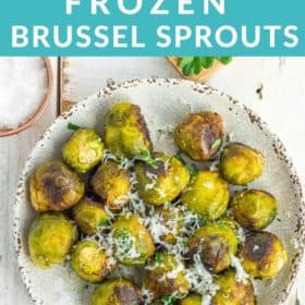 a grey plate with roasted frozen brussel sprouts topped with minced parsley