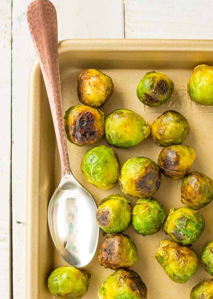 roasted brussels sprouts on a cooking tray with a spoon