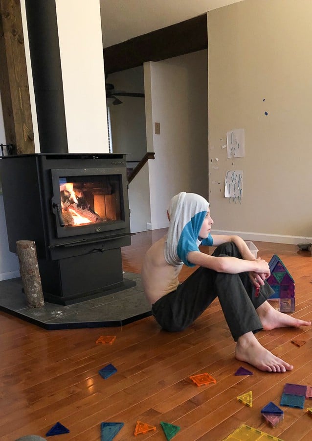 a boy in front of a woodstove