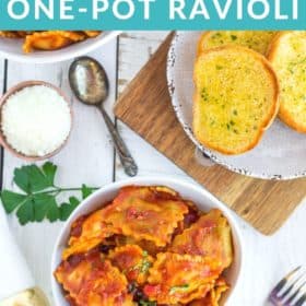 a white bowl of instant pot ravioli with garlic bread and fresh parsley