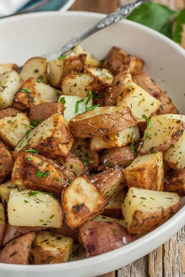 a bowl of red roasted potatoes and a fork.