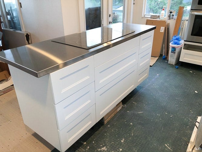 a kitchen island with white cabinets