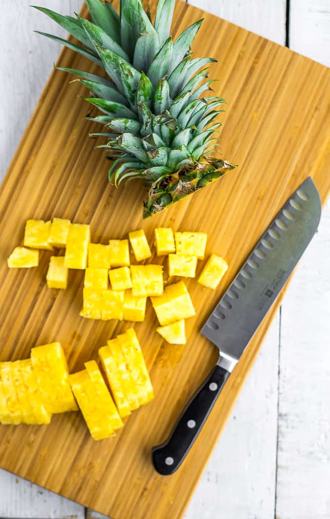 a cutting board with a knife and sliced pineapple.