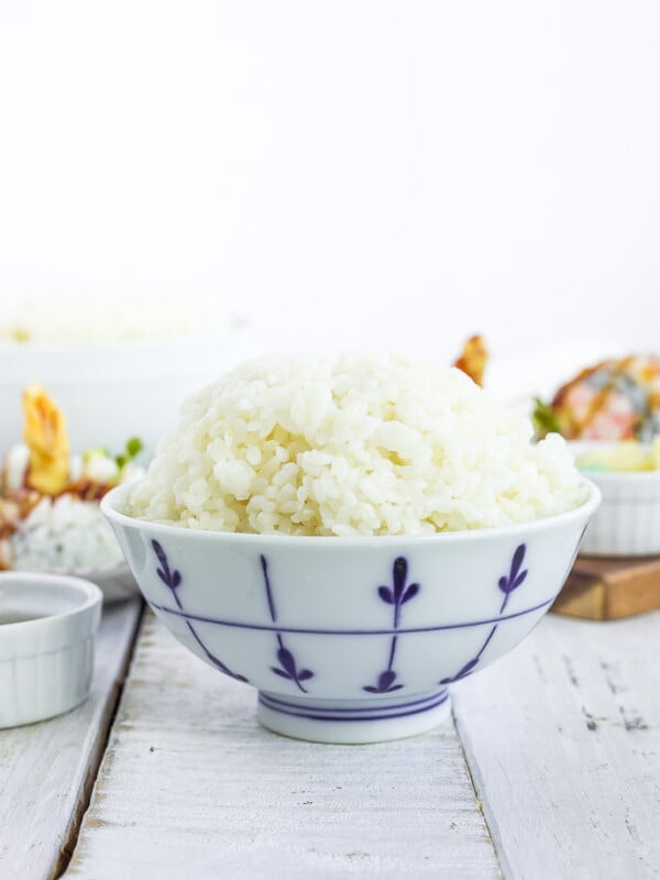 a white bowl with sushi rice on a white board