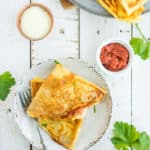2 pizza crepes on a plate with a fork
