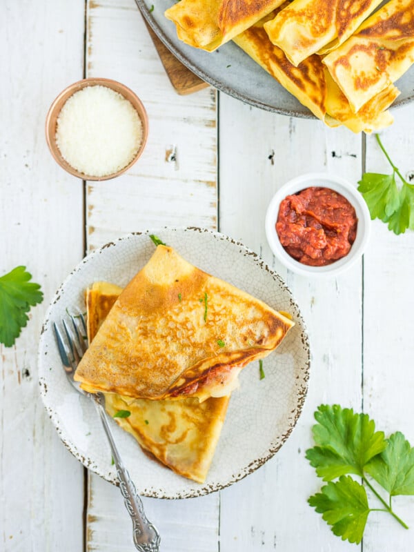 2 pizza crepes on a plate with a fork