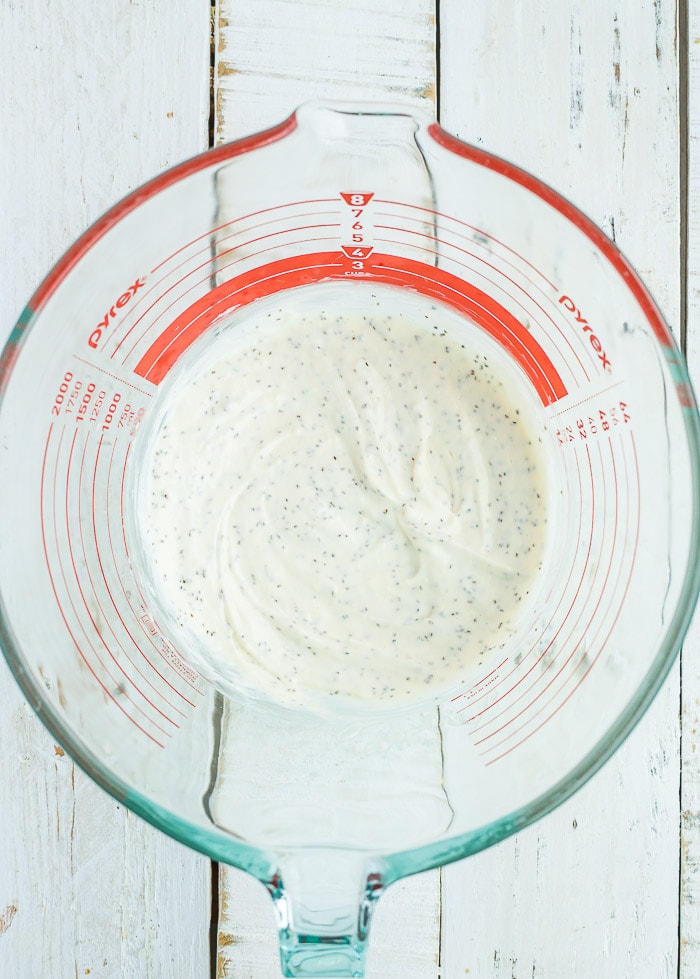 a yogurt sauce in a mixing bowl with spices.