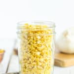 a canning jar of dried garlic on a white board