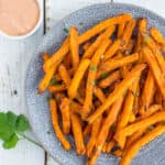 frozen sweet potato fries in an air fryer on a plate