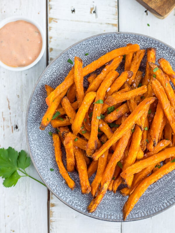 frozen sweet potato fries in an air fryer on a plate