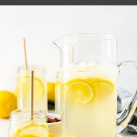 multiple glasses of rose lemonade with slices of lemon and rose petals on a white board
