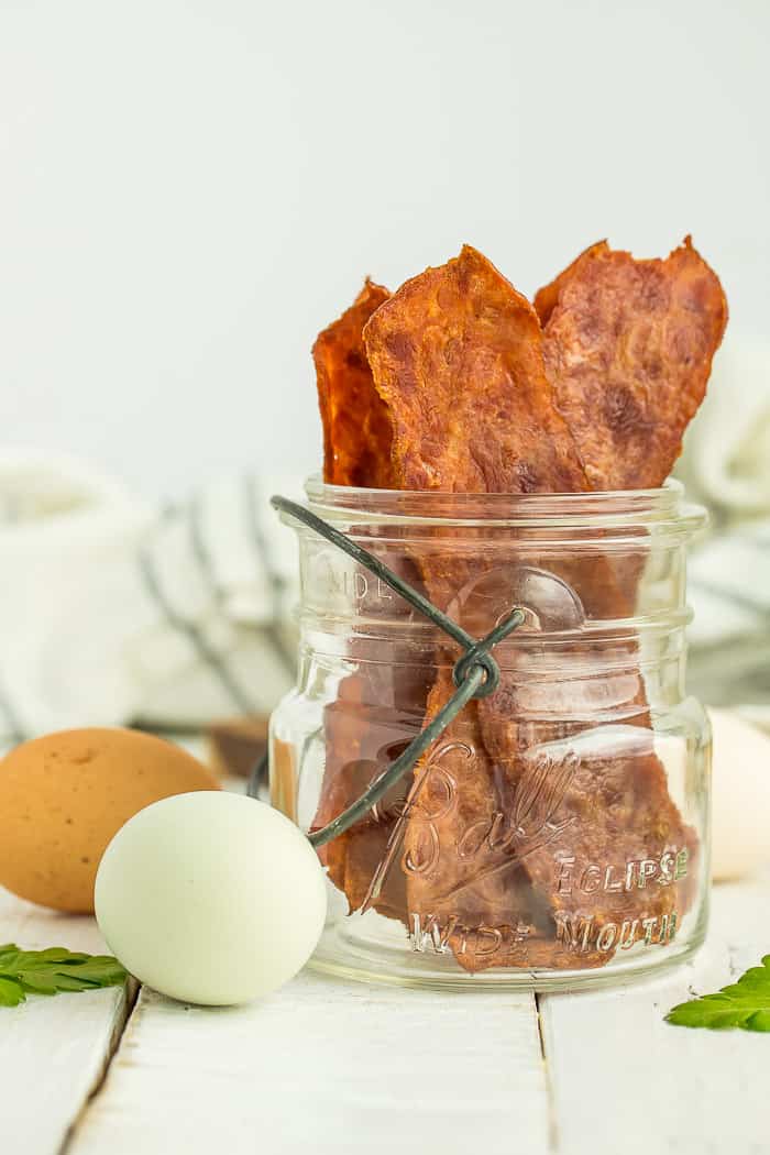 a canning jar with turkey bacon standing up in it 