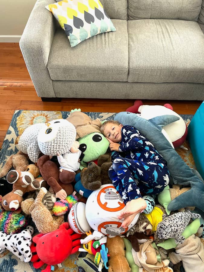 a boy in a pile of stuffed animals
