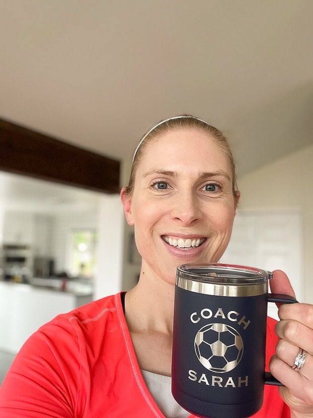 a woman in a pink top holding a coffee mug