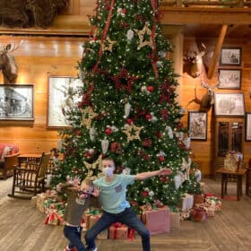 2 boys in front of a Christmas tree