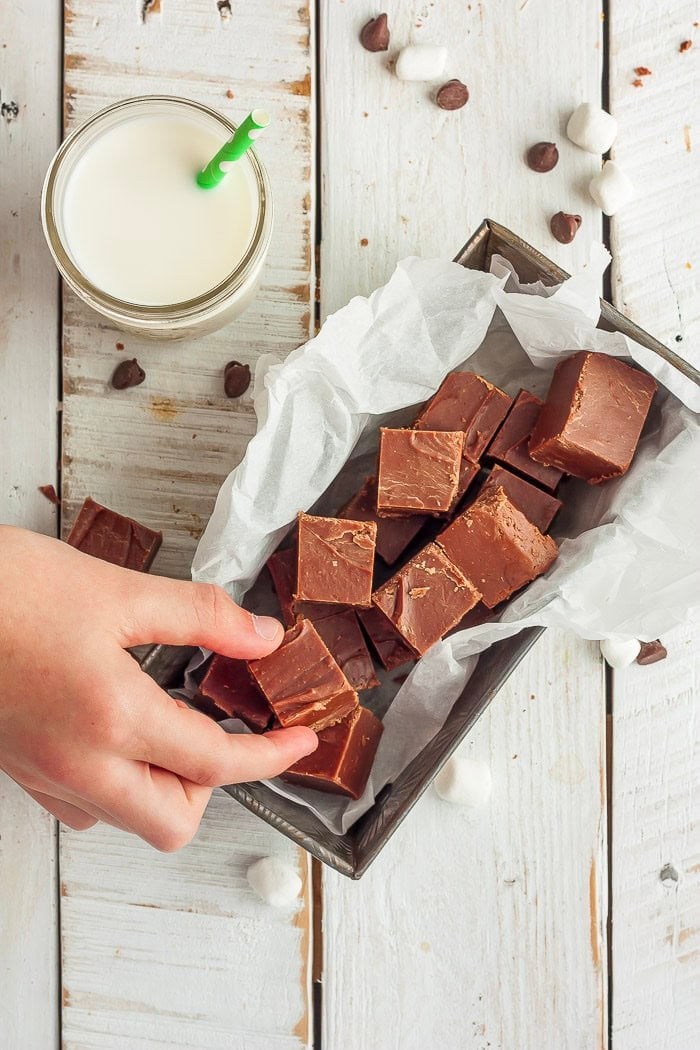 a hand reaching for a dish of old-fashioned chocolate fudge.