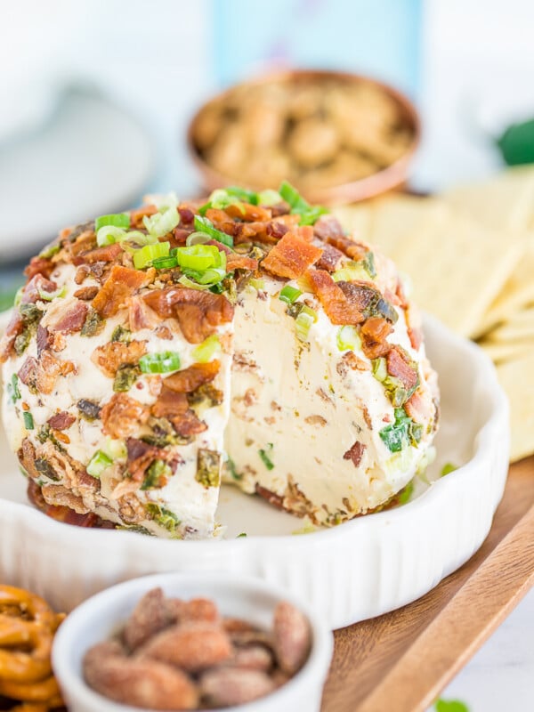 a side profile of a jalapeno popper cheeseball with a slice removed