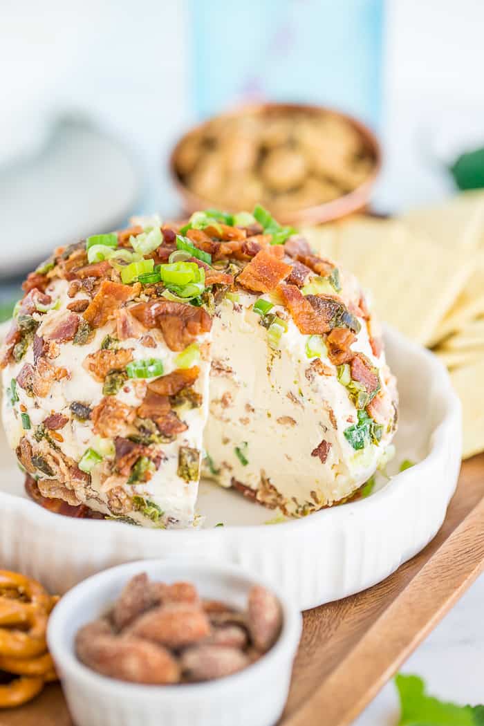 a side profile of a jalapeno popper cheeseball with a slice removed