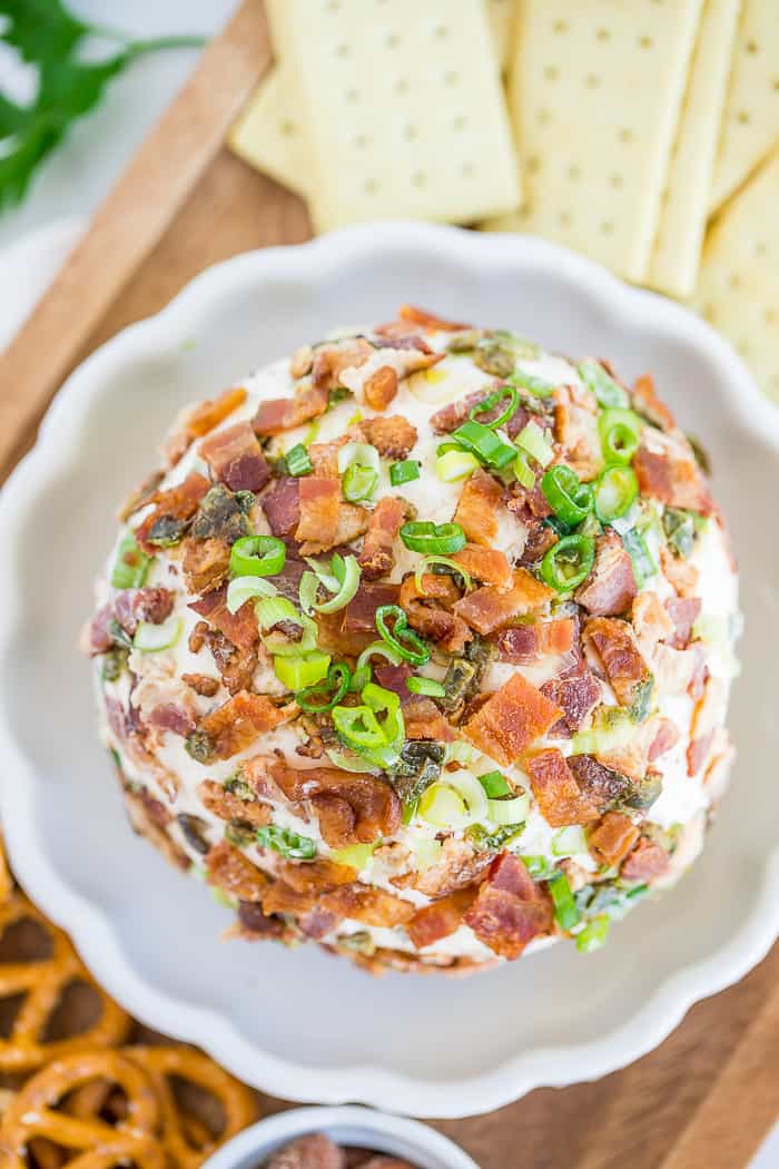 a cheeseball topped with crispy bacon and chopped green onions