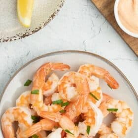 shrimp on a plate with a lemon wedge