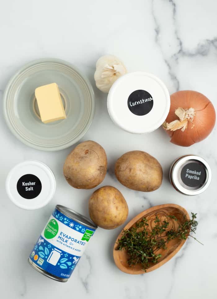 butter, potatoes, a can of evaporated milk and other ingredients on a white board