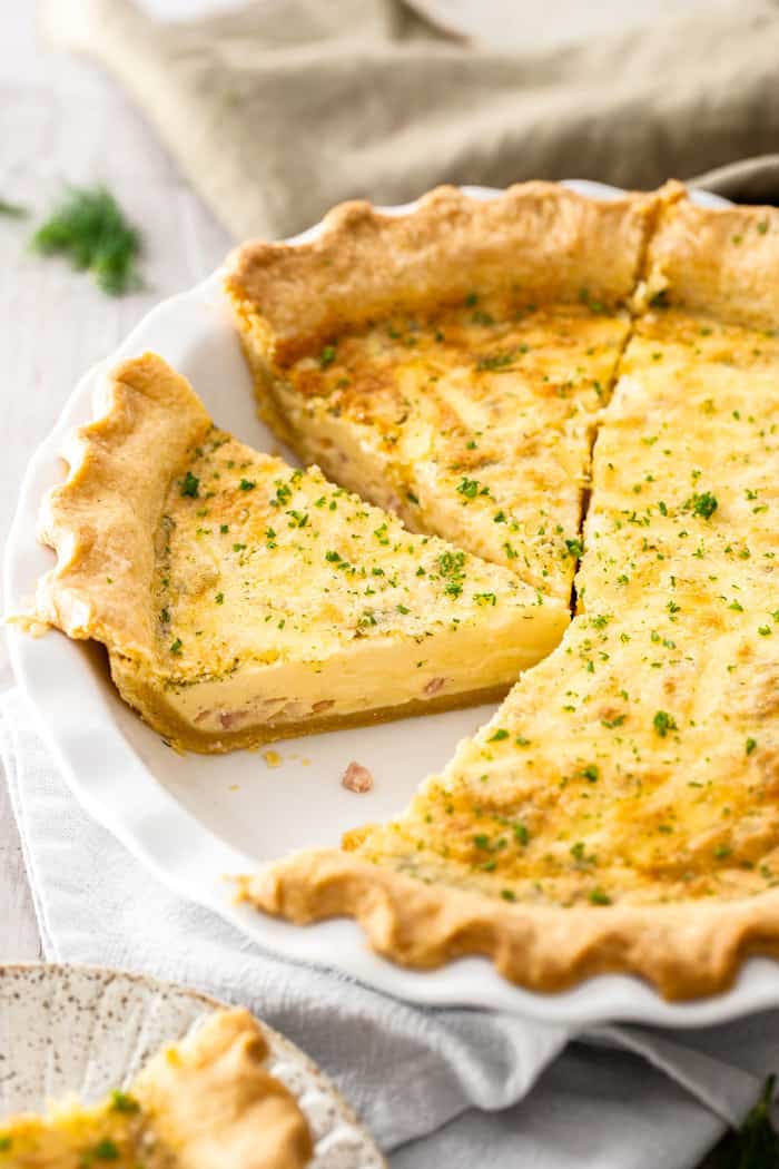 a quiche in a pie plate with 1 slice removed