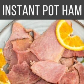a plate of ham with oranges and parsley.