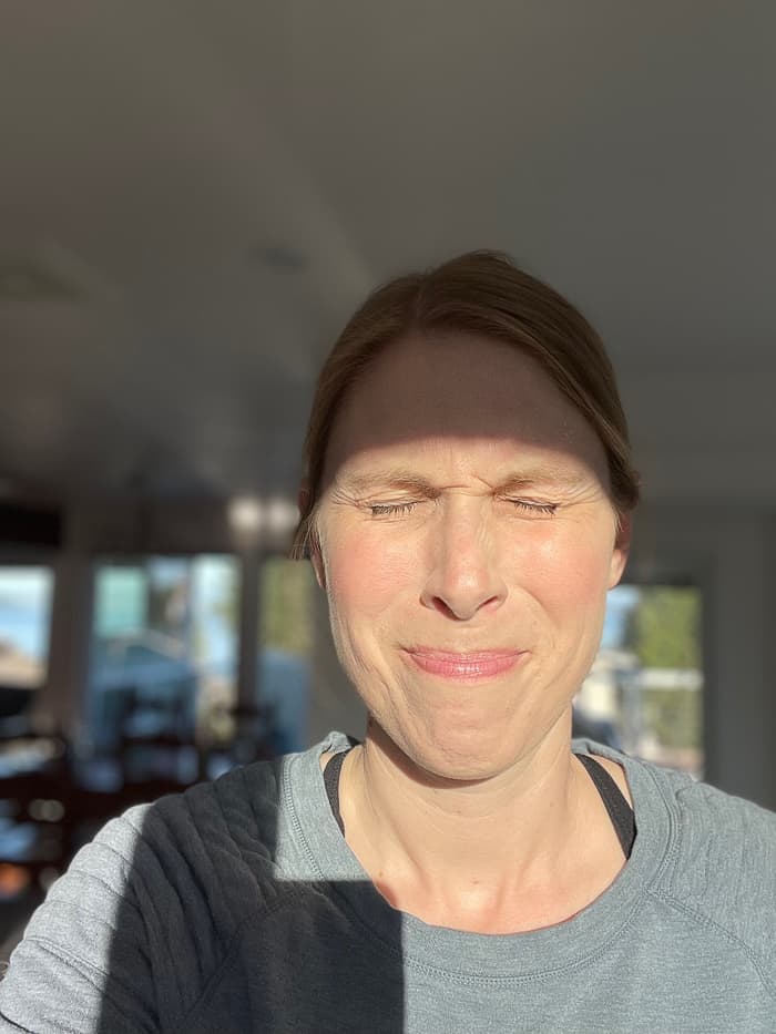 a woman squinting with sun in her face