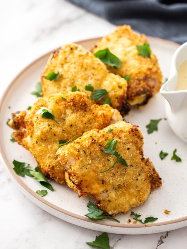 4 air fryer chicken cordon bleu cutlets on a plate topped with parsley.