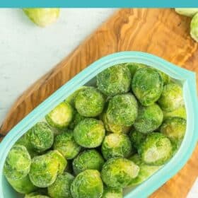 a blue reusable silicone bag full of frozen brussel sprouts.