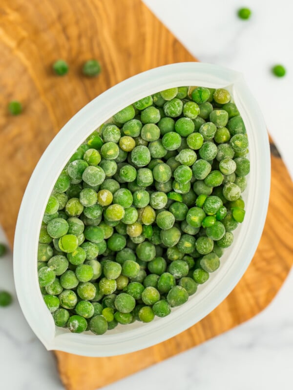 a silicone container of frozen peas.