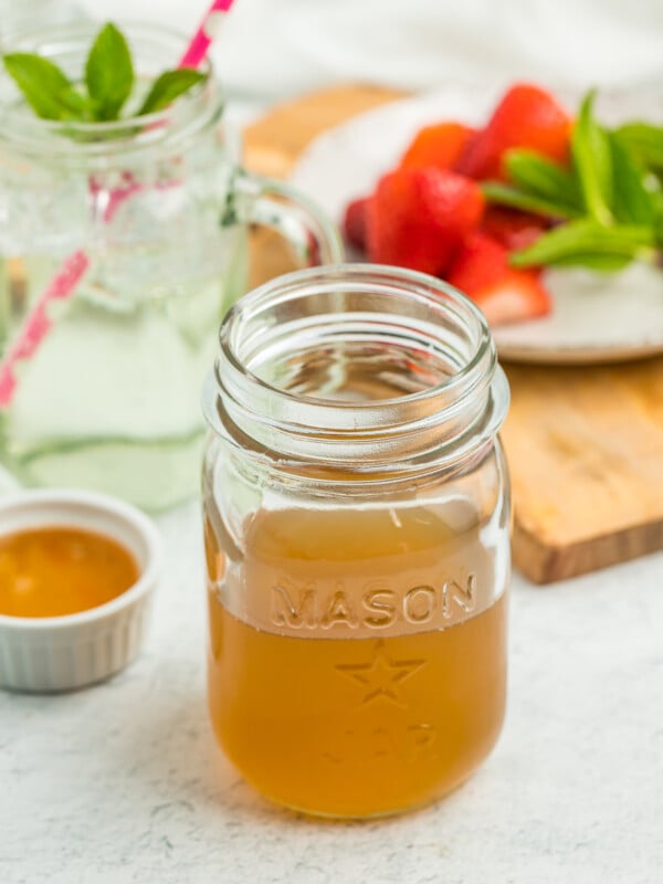 a pint canning jar with honey simple syrup on a white board