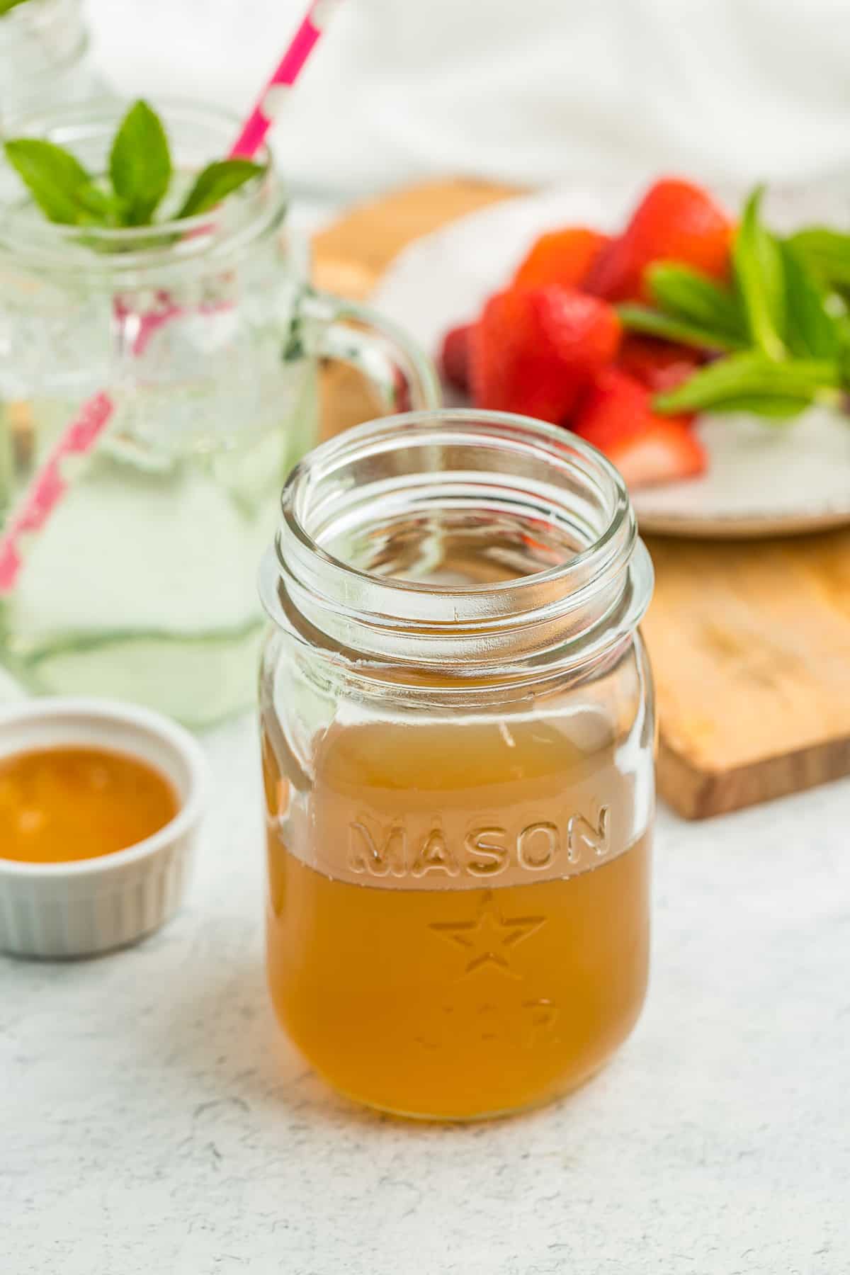a pint canning jar with honey simple syrup on a white board