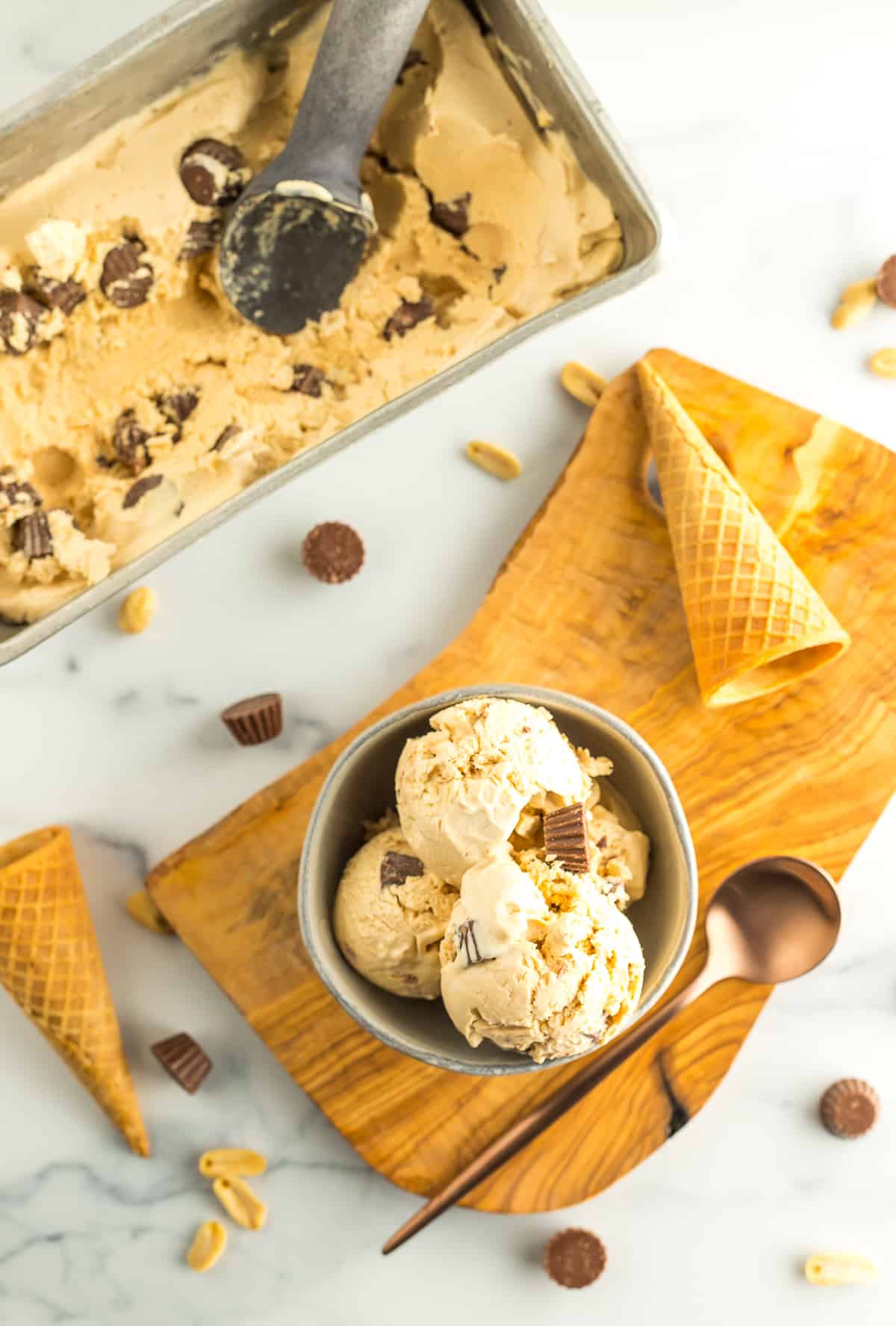 a dish of homemade no churn ice cream in a bowl with cones, and mini peanut butter cups.