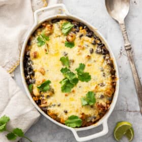 a turkey and rice casserole in a white baking dish topped with cilantro.