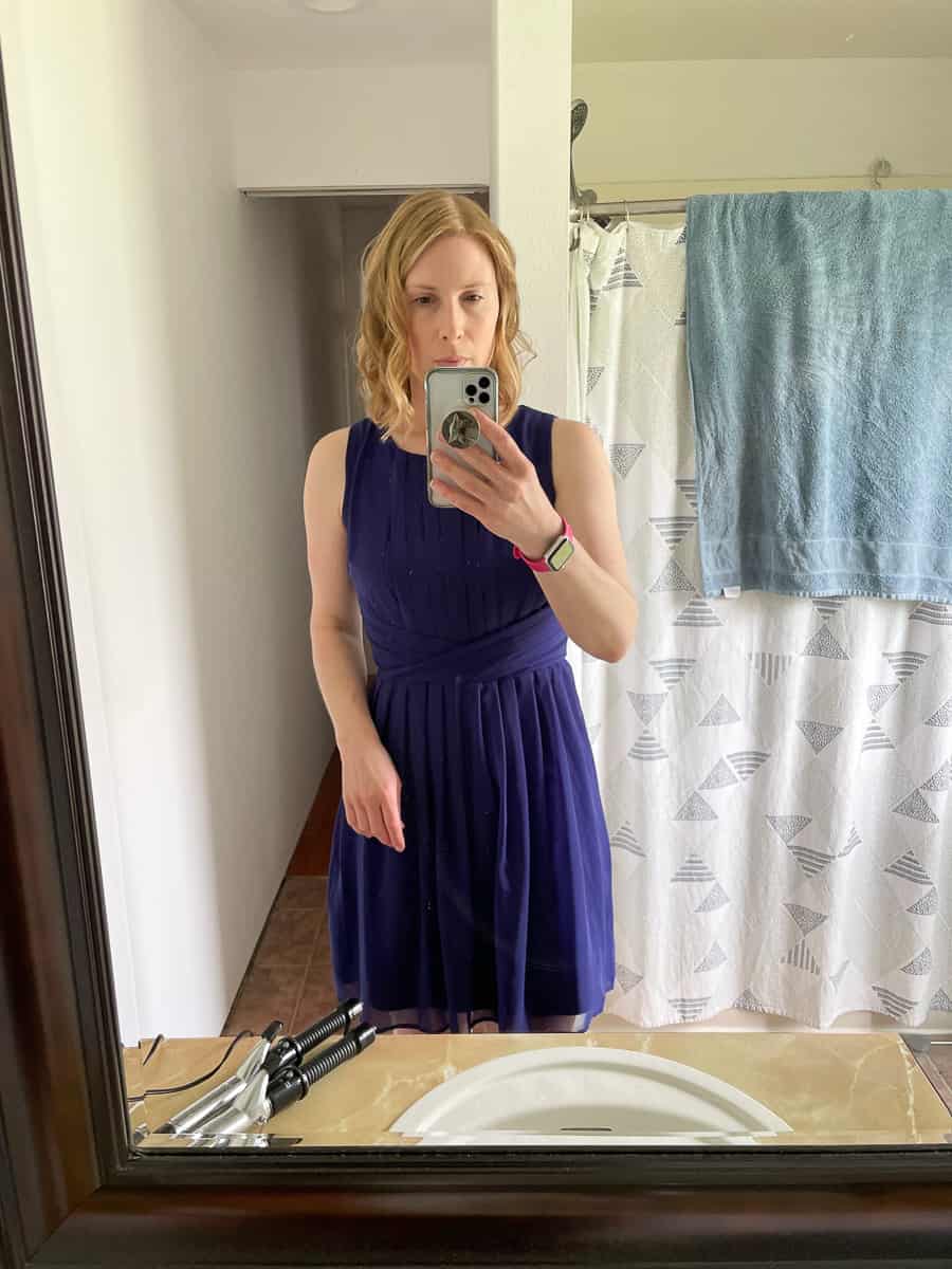 a woman in a blue dress taking a photo