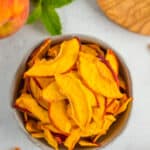 a grey bowl filled with dried peach slices.