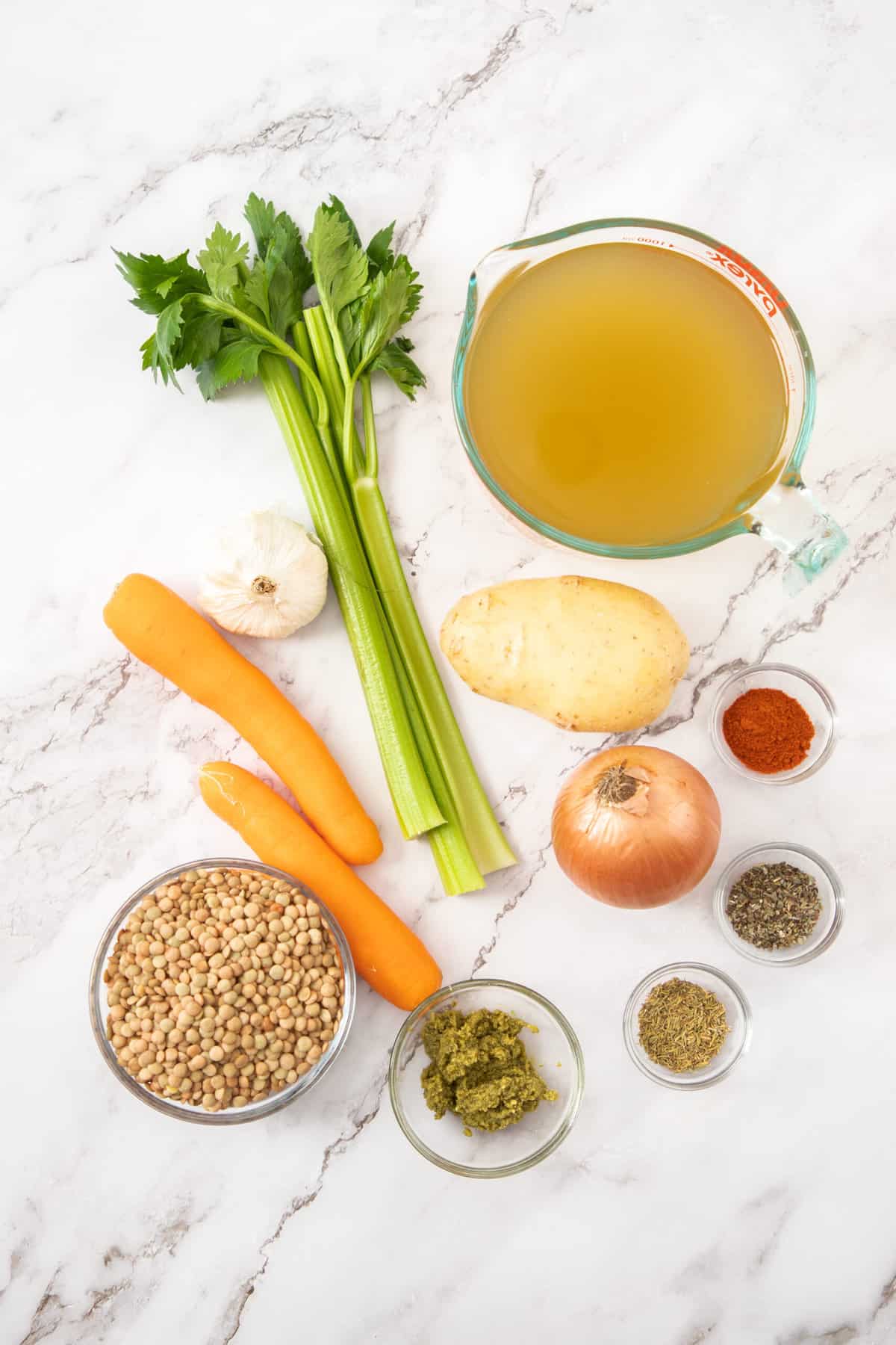 veggies, broth, and lentils on a white board.