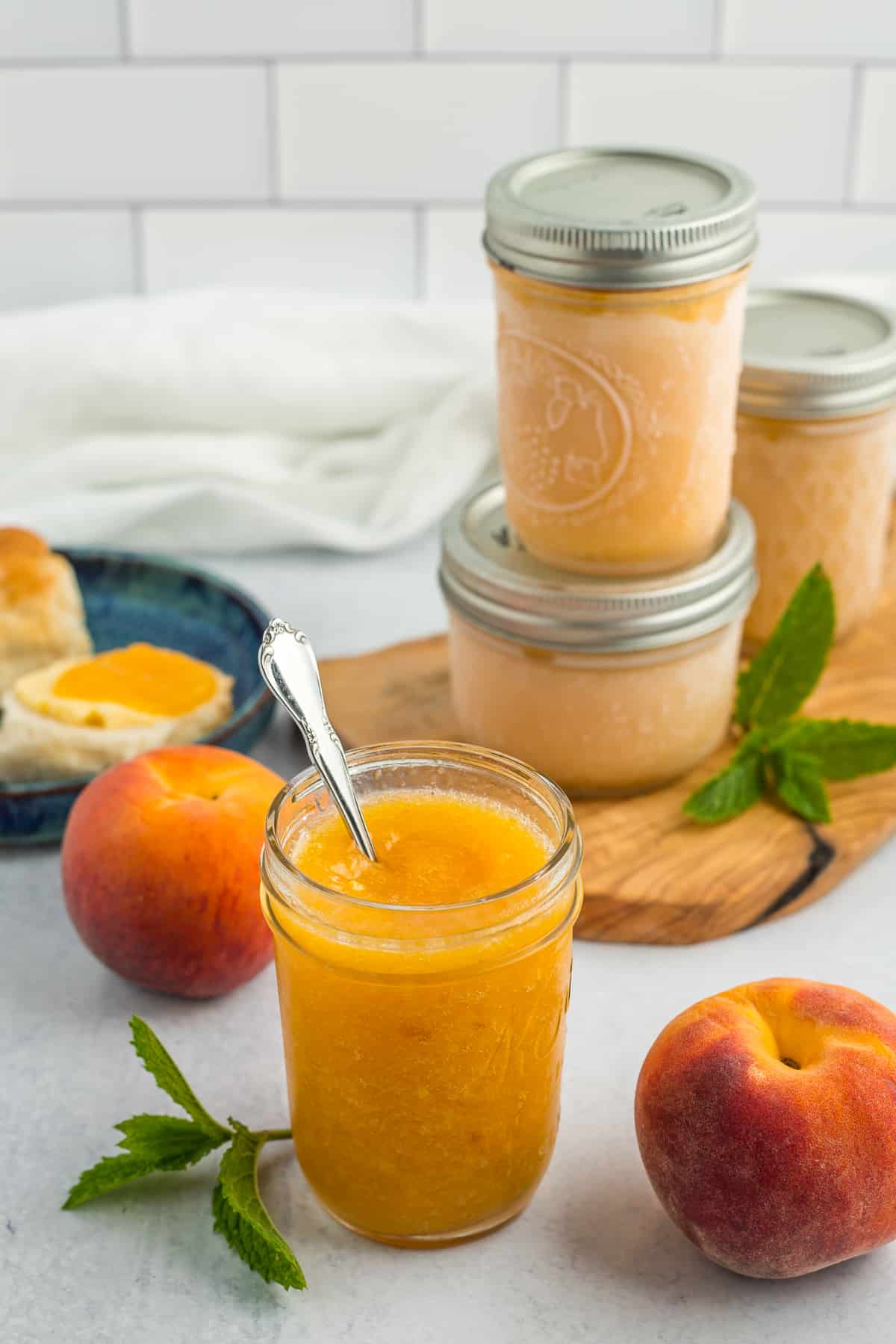 a jar of freezer peach jam with a spoon in it.