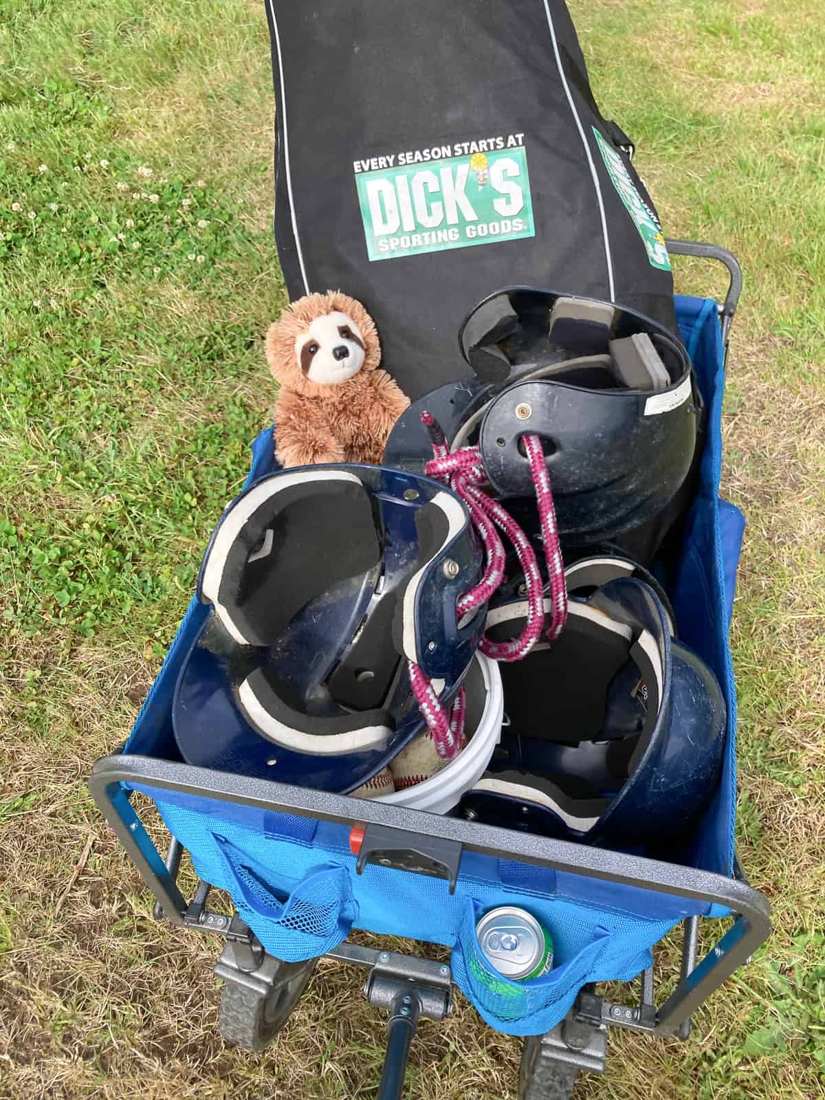 a wagon full of baseball equipment and a stuffed sloth