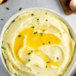 a bowl of Boursin mashed potatoes topped with butter and chives.