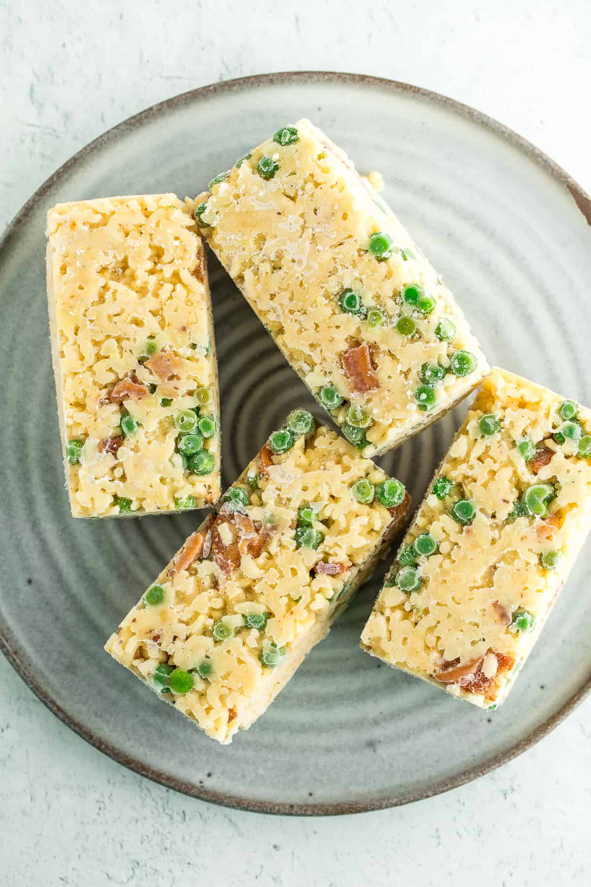 Frozen cubes of bacon and pea risotto on a grey plate.