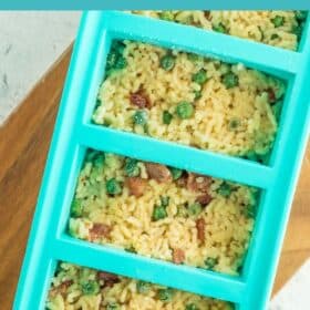 Teal Souper Cubes filled with frozen risotto on a wooden board.